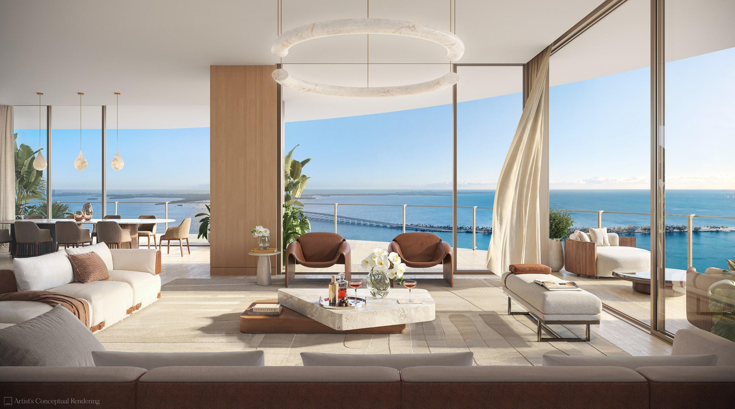 A curved living room at 619 Brickell opening through floor-to-ceiling glass to the terrace and Biscayne Bay