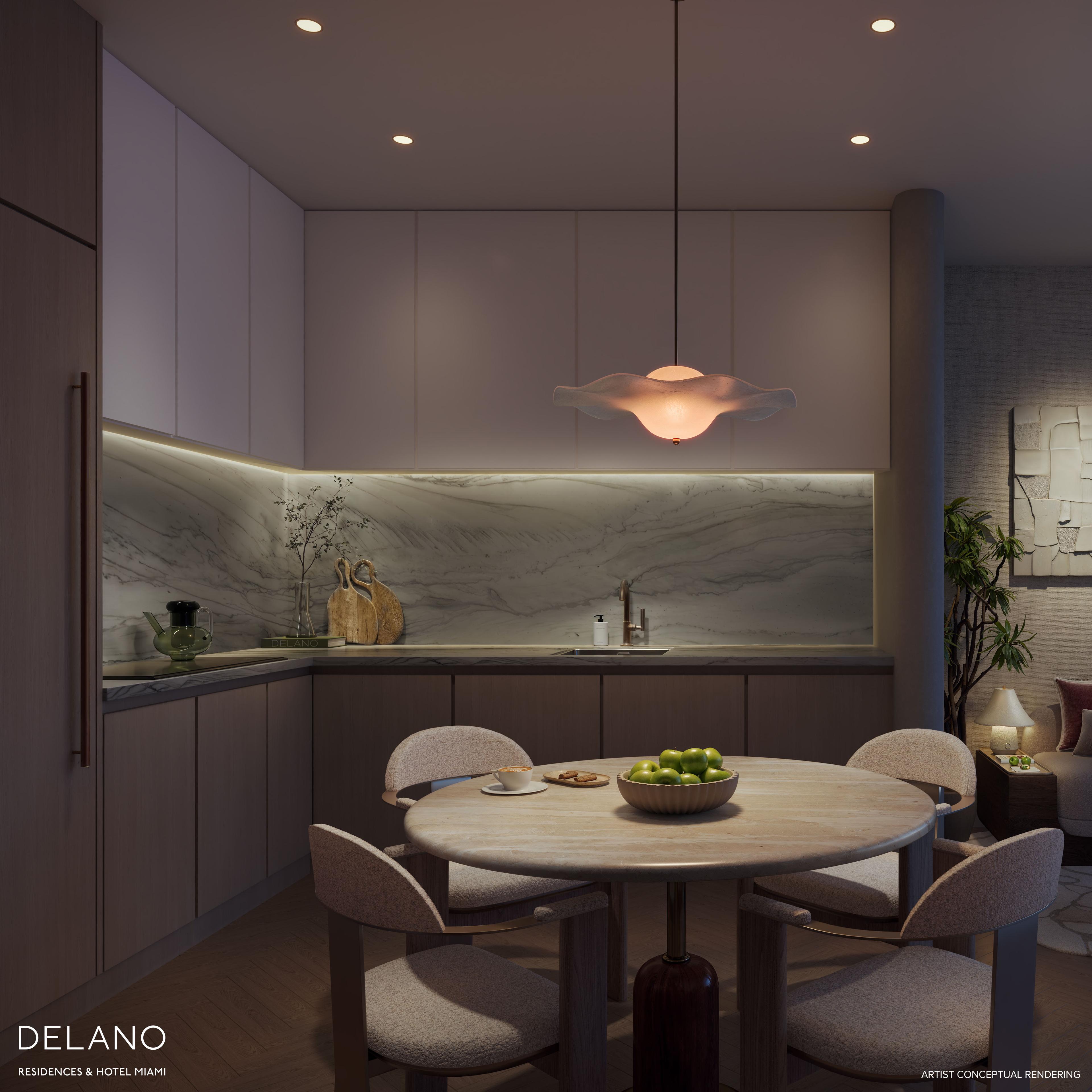 Residence kitchen with a veined marble backsplash and pale oak cabinetry by Meyer Davis