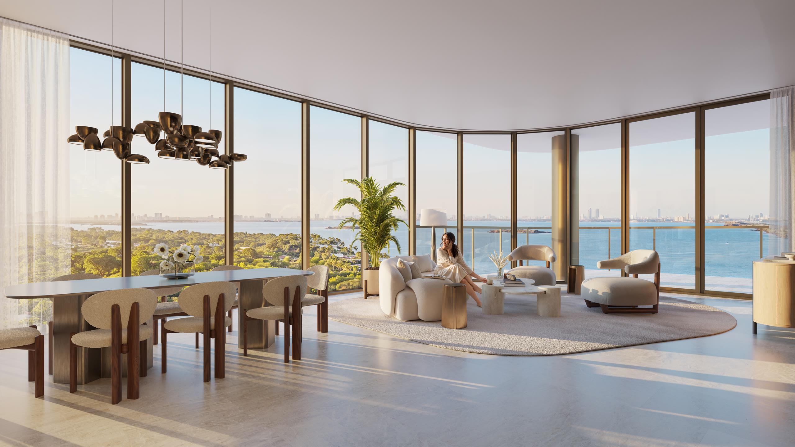 Great room with curved floor-to-ceiling glass framing Biscayne Bay at Kempinski Residences